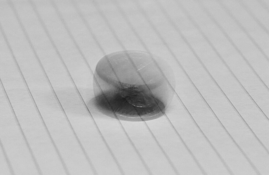 blurry image of a coin against a piece of paper