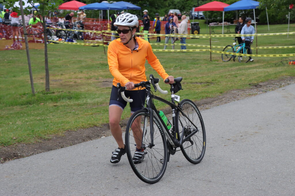 female biker walking her bike to path