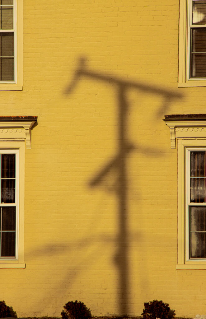 telephone shadow on yellow wall